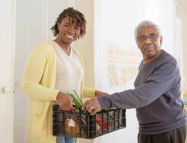 young woman delivering food for elderly man for AmeriCorps Seniors in Southern Illinois